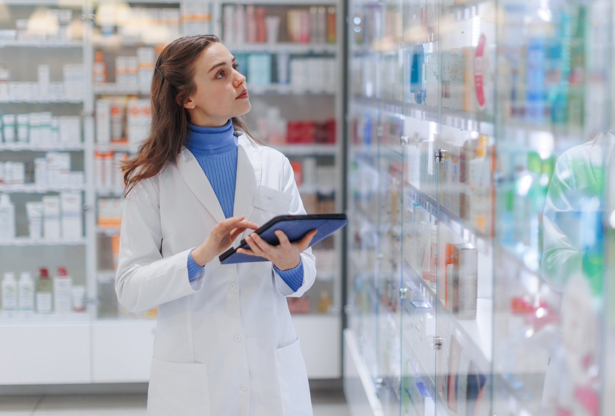 Young pharmacist checking medicine stock in pharmacy